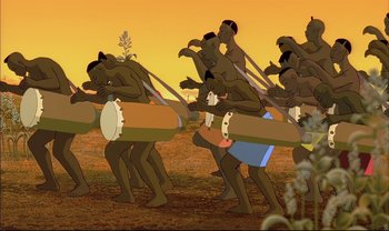 Movie still from “Kirikou and the Sorceress” (1998), directed by Raymond Burlet – A group of men are playing drums in a field; Wide shot, Low angle