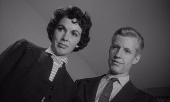 Movie still from “Kiss Me Deadly” (1955), directed by Robert Aldrich – An old photo of a man and a woman posing for a picture; Close Up shot, Low angle