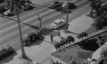 Movie still from “Kiss Me Deadly” (1955), directed by Robert Aldrich – An aerial view of a man walking down a street; Extreme Wide shot, High angle