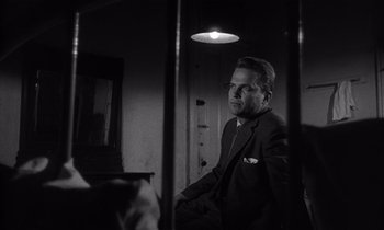 Movie still from “Kiss Me Deadly” (1955), directed by Robert Aldrich – A black and white photo of a man in a suit; Close Up shot, Low angle