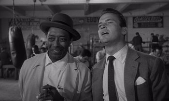 Movie still from “Kiss Me Deadly” (1955), directed by Robert Aldrich – A black and white photo of two men standing next to each other; Medium shot, Low angle