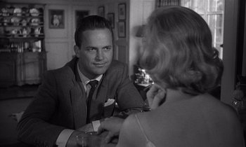 Movie still from “Kiss Me Deadly” (1955), directed by Robert Aldrich – A black and white photo of a man and a woman sitting at a table; Close Up shot, Over the shoulder angle