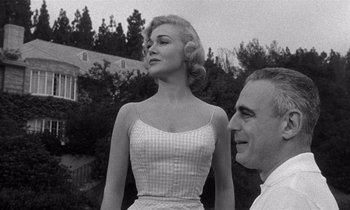 Movie still from “Kiss Me Deadly” (1955), directed by Robert Aldrich – An old photo of a man and a woman; Medium shot, Low angle