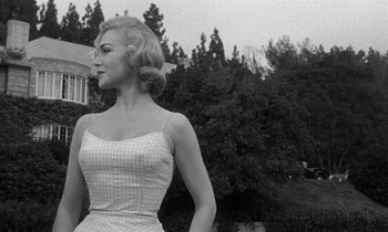 Movie still from “Kiss Me Deadly” (1955), directed by Robert Aldrich – A black and white photo of a woman in a dress; Medium shot, Low angle