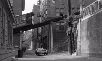 Movie still from “Kiss Me Deadly” (1955), directed by Robert Aldrich – A black and white photo of a car parked on the side of the road; Extreme Wide shot, High angle