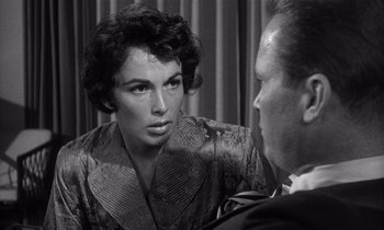 Movie still from “Kiss Me Deadly” (1955), directed by Robert Aldrich – An old photo of a man and a woman looking at each other; Close Up shot, Over the shoulder angle