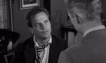 Movie still from “Kiss Me Deadly” (1955), directed by Robert Aldrich – A man wearing a suit and tie talking to another man; Close Up shot, Over the shoulder angle