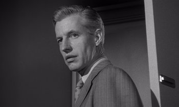 Movie still from “Kiss Me Deadly” (1955), directed by Robert Aldrich – Black and white photograph of a man in a suit; Close Up shot, Low angle