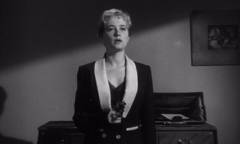 Movie still from “Kiss Me Deadly” (1955), directed by Robert Aldrich – A black and white photo of a woman holding a gun; Medium shot, Low angle