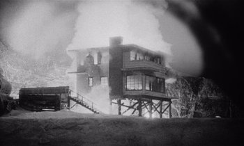 Movie still from “Kiss Me Deadly” (1955), directed by Robert Aldrich – An old black and white photo of a house on fire; Extreme Wide shot, Low angle