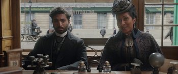 Movie still from “Enola Holmes 2” (2022), directed by Harry Bradbeer – A man and a woman sitting at a table in a restaurant; Medium shot, Over the shoulder angle