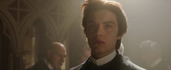 Movie still from “Enola Holmes 2” (2022), directed by Harry Bradbeer – A young man in a priest's outfit looking at the camera; Close Up shot, Low angle
