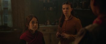 Movie still from “Enola Holmes 2” (2022), directed by Harry Bradbeer – Two young women standing next to each other in a room; Medium shot, Over the shoulder angle