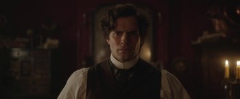 Movie still from “Enola Holmes 2” (2022), directed by Harry Bradbeer – A person wearing a suit and tie; Close Up shot, Over the shoulder angle