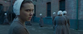 Movie still from “Enola Holmes 2” (2022), directed by Harry Bradbeer – A group of women in a courtyard with a brick building in the background; Close Up shot, Over the shoulder angle