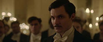 Movie still from “Enola Holmes 2” (2022), directed by Harry Bradbeer – A person wearing a suit and a bow tie; Close Up shot, Low angle