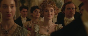 Movie still from “Enola Holmes 2” (2022), directed by Harry Bradbeer – A woman in a white dress with a long necklace; Close Up shot, Over the shoulder angle