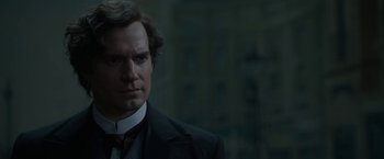 Movie still from “Enola Holmes 2” (2022), directed by Harry Bradbeer – A person wearing a suit and tie; Close Up shot, Over the shoulder angle