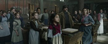 Movie still from “Enola Holmes 2” (2022), directed by Harry Bradbeer – A group of people standing in a room; Medium shot, Low angle