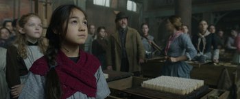 Movie still from “Enola Holmes 2” (2022), directed by Harry Bradbeer – A group of people standing in a room; Close Up shot, Over the shoulder angle