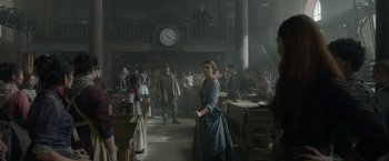 Movie still from “Enola Holmes 2” (2022), directed by Harry Bradbeer – A group of people standing in a room with a clock; Wide shot, Low angle