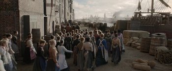 Movie still from “Enola Holmes 2” (2022), directed by Harry Bradbeer – A group of people walking down a street; Extreme Wide shot, High angle