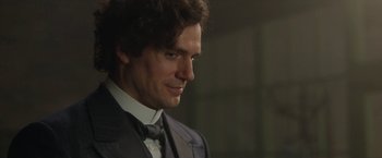 Movie still from “Enola Holmes 2” (2022), directed by Harry Bradbeer – A person wearing a suit and tie; Close Up shot, Over the shoulder angle