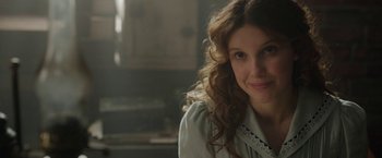 Movie still from “Enola Holmes 2” (2022), directed by Harry Bradbeer – A beautiful woman with long curly brown hair; Close Up shot, Over the shoulder angle