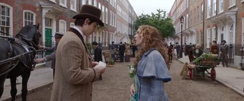 Movie still from “Enola Holmes 2” (2022), directed by Harry Bradbeer – A man and a woman are standing in the street; Medium shot, Over the shoulder angle