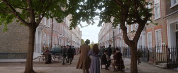 Movie still from “Enola Holmes 2” (2022), directed by Harry Bradbeer – A man and a woman holding hands while walking down a street; Wide shot, High angle