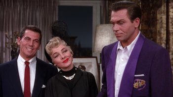 Movie still from “Kiss Me Kate” (1953), directed by George Sidney – A man and a woman standing next to each other in a room; Medium shot, Low angle