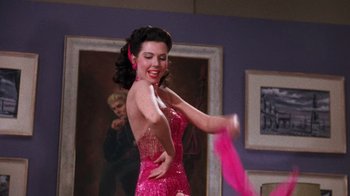 Movie still from “Kiss Me Kate” (1953), directed by George Sidney – A woman in a pink dress dancing in front of a painting; Medium shot, Low angle