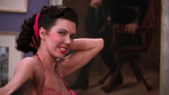 Movie still from “Kiss Me Kate” (1953), directed by George Sidney – A beautiful woman in a pink dress posing for a picture; Close Up shot, Low angle