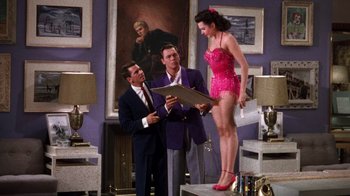 Movie still from “Kiss Me Kate” (1953), directed by George Sidney – A man and a woman standing next to each other in a room; Wide shot, Low angle
