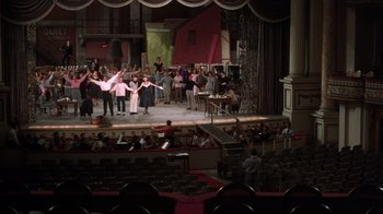 Movie still from “Kiss Me Kate” (1953), directed by George Sidney – A group of people standing on top of a stage in a theater; Extreme Wide shot, High angle