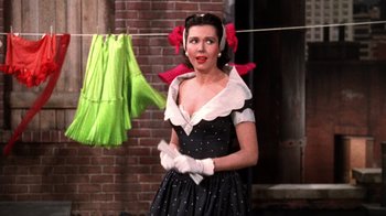 Movie still from “Kiss Me Kate” (1953), directed by George Sidney – A woman in a black and white polka dot dress and white gloves; Medium shot, Low angle