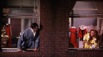 Movie still from “Kiss Me Kate” (1953), directed by George Sidney – A man and a woman are looking out of a window; Wide shot, Low angle