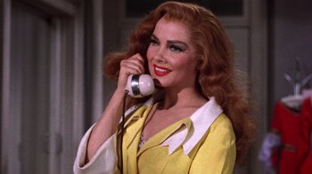 Movie still from “Kiss Me Kate” (1953), directed by George Sidney – A woman talking on a phone while wearing a yellow outfit; Close Up shot, Low angle