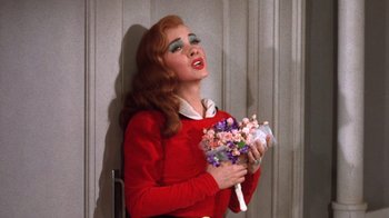 Movie still from “Kiss Me Kate” (1953), directed by George Sidney – A woman holding a bouquet of flowers in her hands; Medium shot, High angle