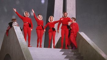 Movie still from “Kiss Me Kate” (1953), directed by George Sidney – A group of people dressed in identical red outfits; Wide shot, Low angle