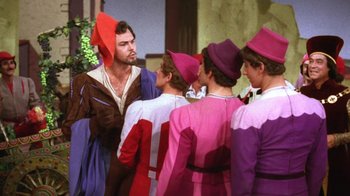 Movie still from “Kiss Me Kate” (1953), directed by George Sidney – A group of men in medieval garb standing next to each other; Medium shot, Over the shoulder angle