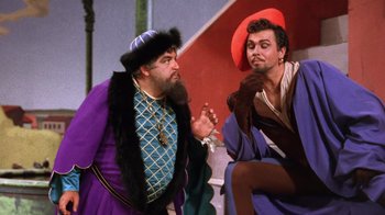 Movie still from “Kiss Me Kate” (1953), directed by George Sidney – Two men dressed in medieval clothing talking to each other; Medium shot, Over the shoulder angle