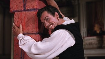 Movie still from “Kiss Me Kate” (1953), directed by George Sidney – A man leaning against a brick wall with his hands on the side of the wall; Medium shot, Low angle