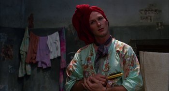 Movie still from “Kiss of the Spider Woman” (1985), directed by Hector Babenco – A man with a red turban on his head; Medium shot, Low angle