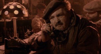 Movie still from “Kiss of the Spider Woman” (1985), directed by Hector Babenco – An older man talking on a phone while sitting at a table; Close Up shot, High angle