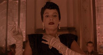 Movie still from “Kiss of the Spider Woman” (1985), directed by Hector Babenco – A woman in a black dress and white gloves; Close Up shot, Low angle