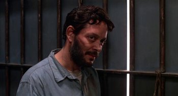 Movie still from “Kiss of the Spider Woman” (1985), directed by Hector Babenco – A man in a jail cell looking at the camera; Close Up shot, Low angle