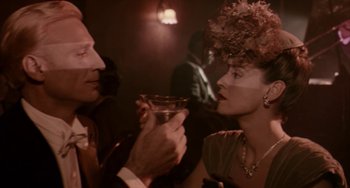 Movie still from “Kiss of the Spider Woman” (1985), directed by Hector Babenco – A man and a woman are holding a drink; Close Up shot, Over the shoulder angle