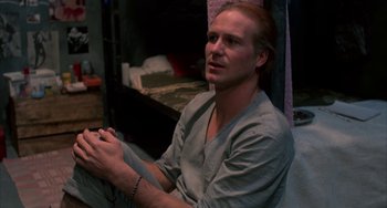 Movie still from “Kiss of the Spider Woman” (1985), directed by Hector Babenco – A man sitting on the ground in a room; Close Up shot, High angle