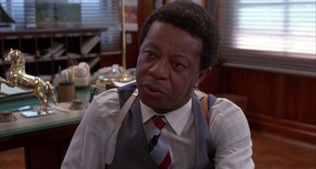 Movie still from “Kiss of the Spider Woman” (1985), directed by Hector Babenco – A person wearing an apron and a tie; Close Up shot, Low angle